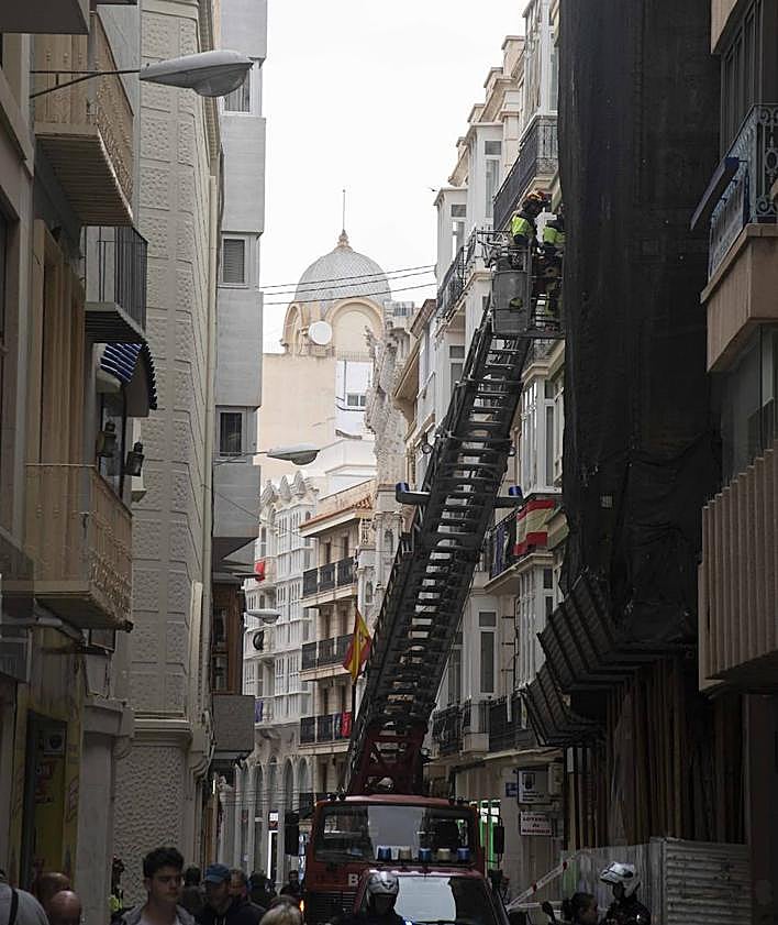 Imagen secundaria 2 - Empleados municipales colocan en la Caridad las rejillas para formar el manto de flor para la Virgen. Preparativos en el interior de la basílica para los actos de hoy. Los bomberos ponen una malla en la Casa Llagostera, de la calle Mayor.