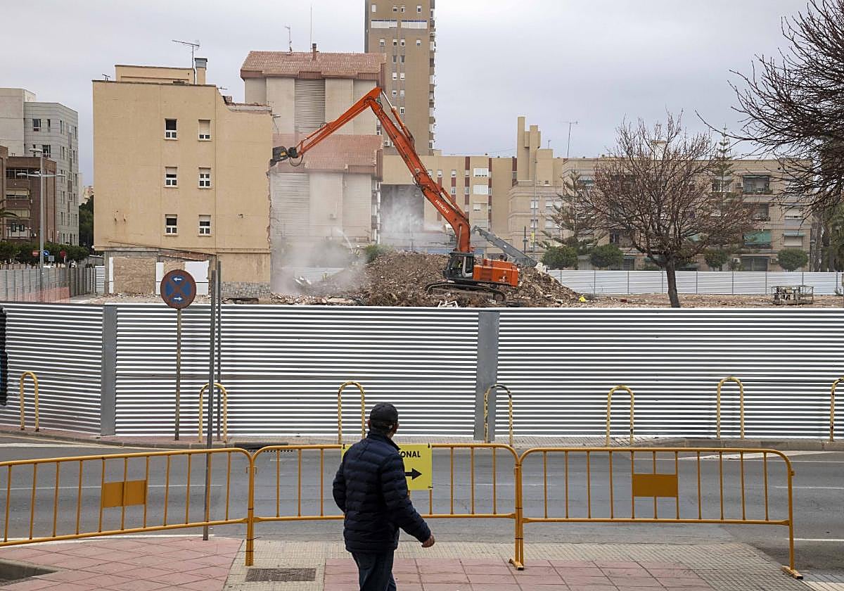Un hombre camina frente a los trabajos de derribo del cuartel.