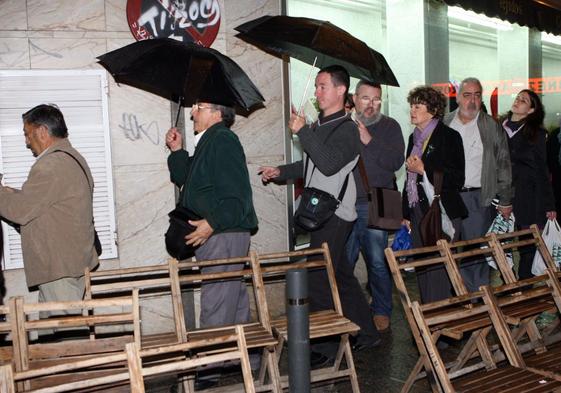 Asistentes a una procesión se retiran ante la lluvia, en una imagen de archivo.