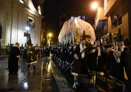 Uno de los pasos de La Esperanza, cubierto por plástico, vuelve a la iglesia de San Pedro bajo la lluvia el pasado domingo.