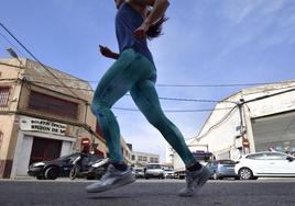 Una chica practica deporte por la calle Pinatar, donde se encuentra la antigua y abandonada sede del Boletín Oficial de la Región de Murcia (BORM).