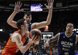 El alero del Valencia Basket Xabi López-Aróstegui trata de superar la defensa de los jugadores del UCAM Todorovic y el estadounidense Troy Caupain, a la derecha.