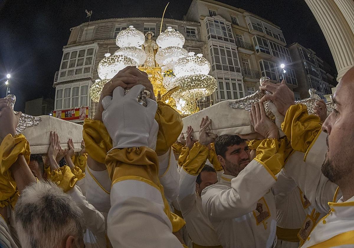 Portapasos de San Juan levantan el trono encarando la basílica de la Caridad, para rendir homenaje a la patrona.