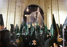 Un paso de la Esperanza, cubierto por plásticos, vuelve a la iglesia de San Pedro de Murcia, tras la suspensión de la procesión de Domingo de Ramos.