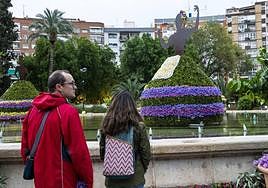 Dos personas contemplan las esculturas de flores de La Circular.
