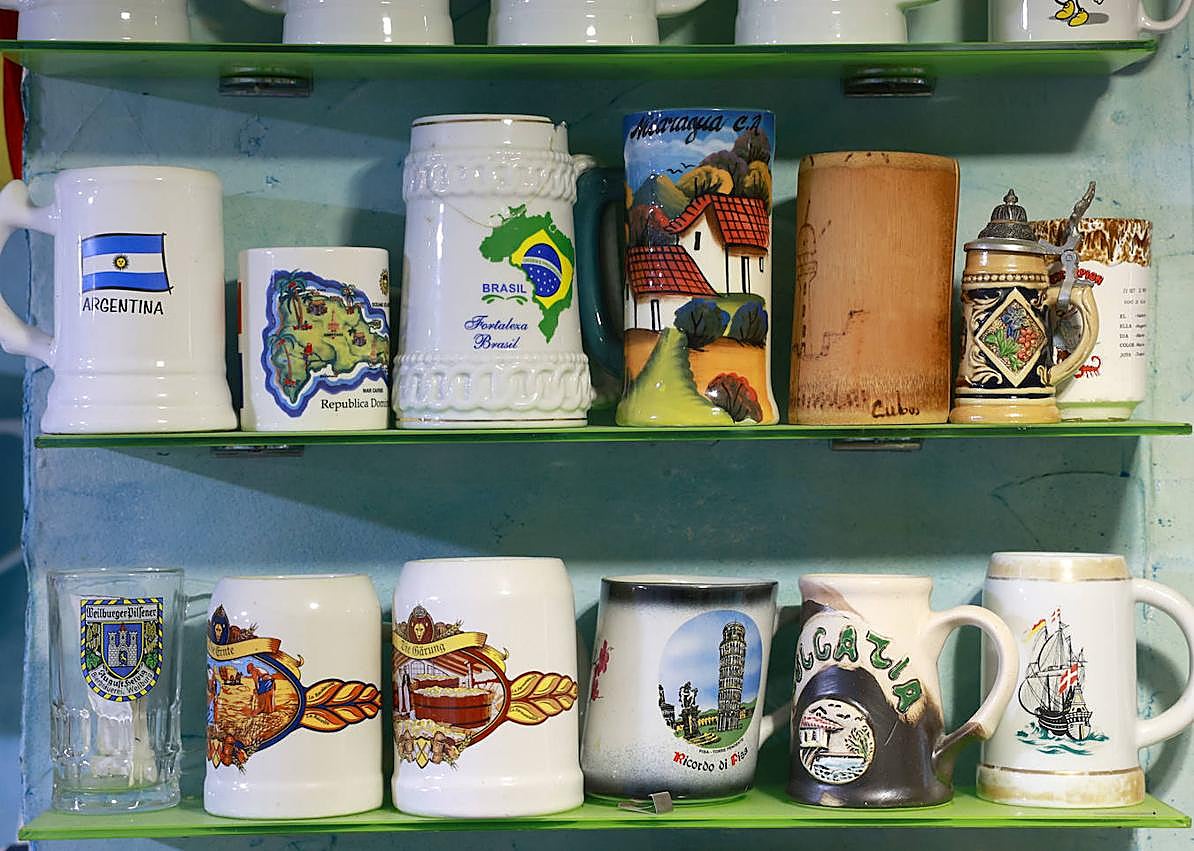 Imagen secundaria 1 - 1. Manuel tiene jarras procedentes de decenas de países, desde Brasil a Tailandia. 2. Imagen de la Virgen de la Fuensanta, flores y extintor contra incendios, no válido para los fuegos bucodentales.