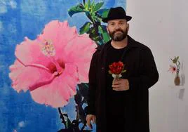 Manuel Pérez, junto a una de sus obras y portando una creación floral de Fernando Ríos.