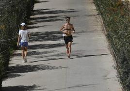 Dos jóvenes hacen deporte en el entorno del río en Murcia, en un día caluroso.