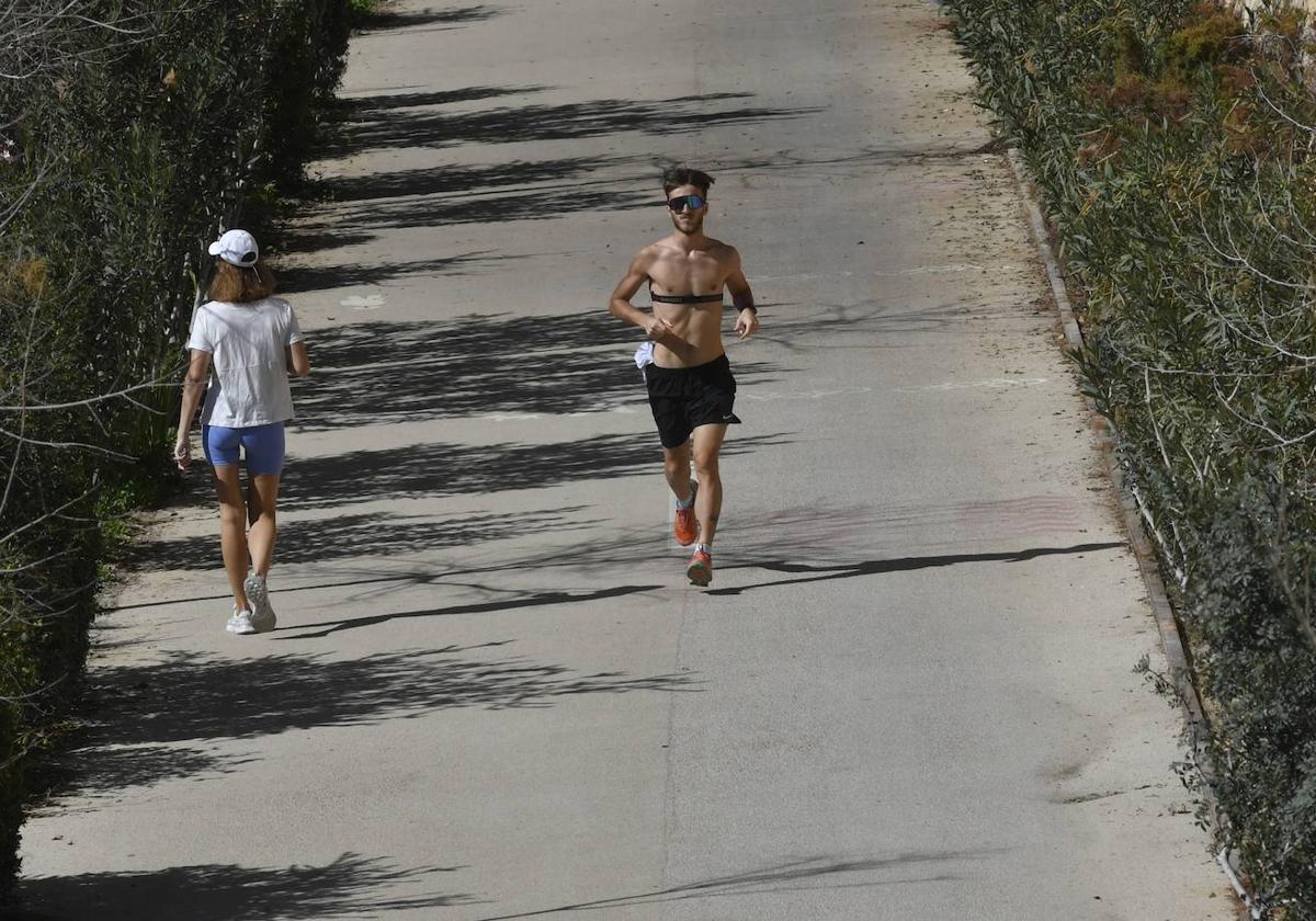 Dos jóvenes hacen deporte en el entorno del río en Murcia, en un día caluroso.