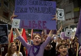 Una joven sostiene una pancarta en contra de la violencia de género.