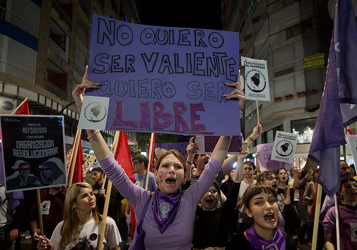 Una joven sostiene una pancarta en contra de la violencia de género.