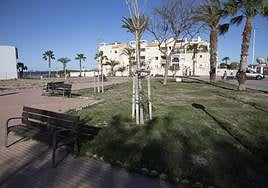 Una mujer pasea a su perro por la zona verde de la Plaza del Rocío, en Los Nietos.