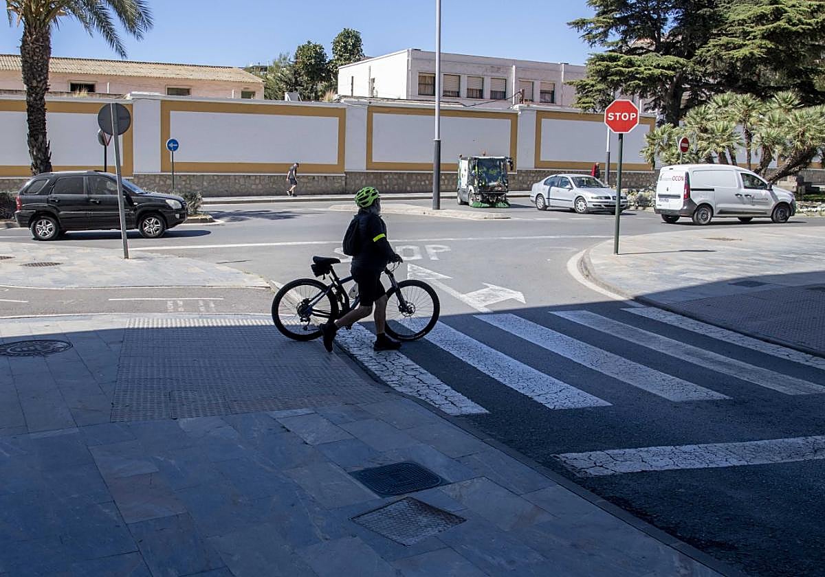 Un ciclista cruza a pie el paso peatonal en la calle Real, donde existe un tramo sin conectar.