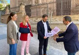 El portavoz del PSOE junto a ediles socialistas observa las imágenes antiguas de la colegiata ante la fachada principal, de la que se ha eliminado la escalinata.