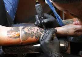 Un tatuador repasa un dibujo, en una imagen de archivo.