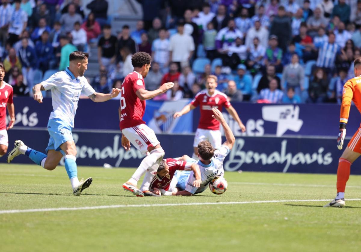 Marcos Mauro, defensa del Real Murcia, pugna desde el suelo con Dani Lorenzo, del Málaga.