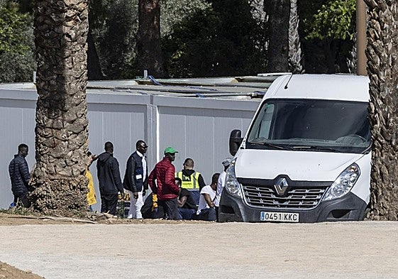 Un grupo de inmigrantes africanos conversa con personal de Accem en el campamento temporal, junto al antiguo Hospital Naval, en Tentegorra, ayer.