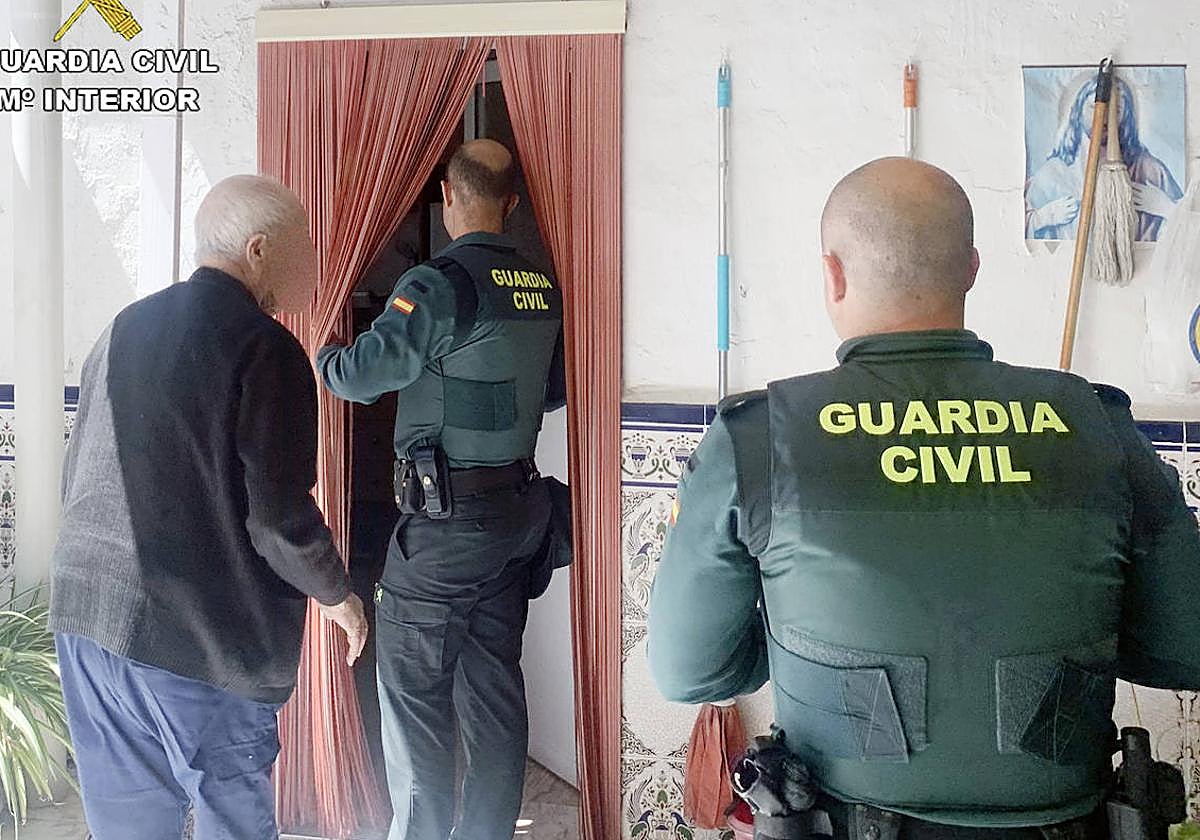 Dos agentes de la Guardia Civil junto al vecino de 92 años afectado por el incendio de su vivienda en Fortuna.