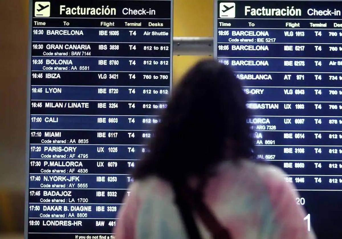 Una chica observa la pantalla de vuelos en un aeropuerto.