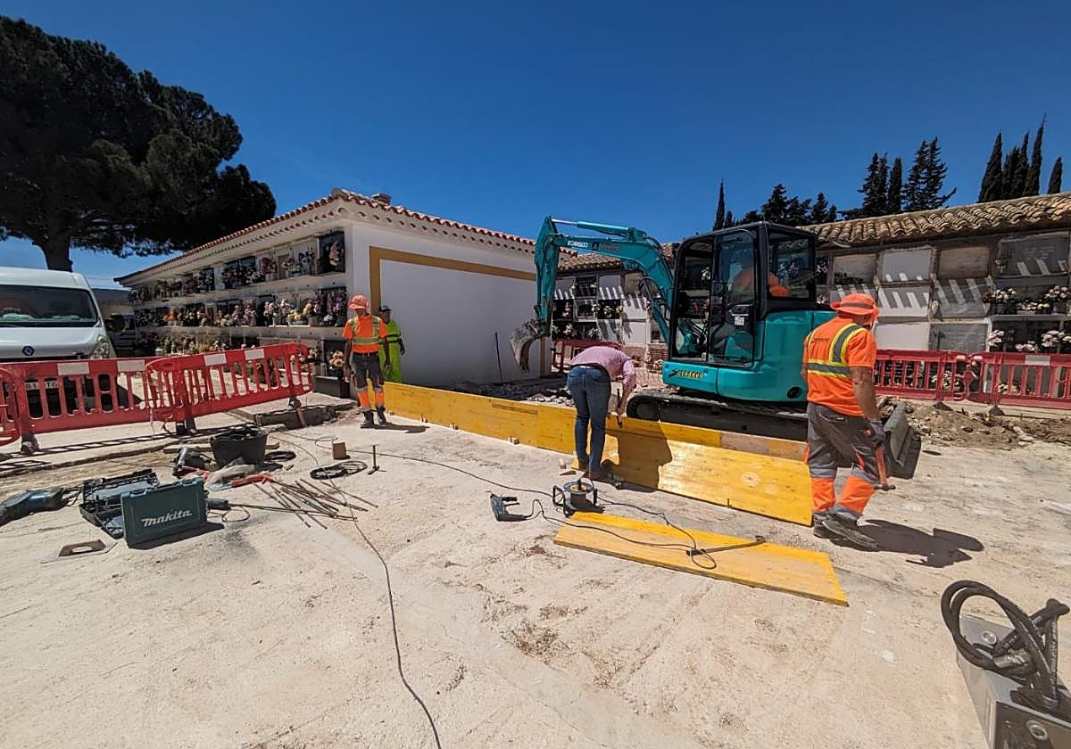 Varios obreros, ayer por la mañana, trabajando en el cementerio.