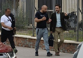 Dos de los procesados abandonan el Palacio de Justicia acompañados de uno de los abogados.