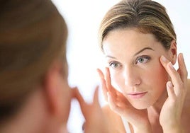 Una mujer se aplica una crema para la cara.