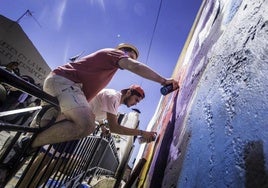 Dos artistas pintan la pared de una vivienda durante una edición pasada de los Murales de San Isidro.