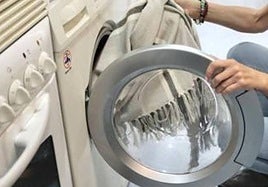 Imagen de archivo de una persona poniendo una lavadora
