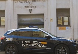 Coche patrulla de la Policía Nacional estacionado delante de la puerta de la comisaría de Murcia.