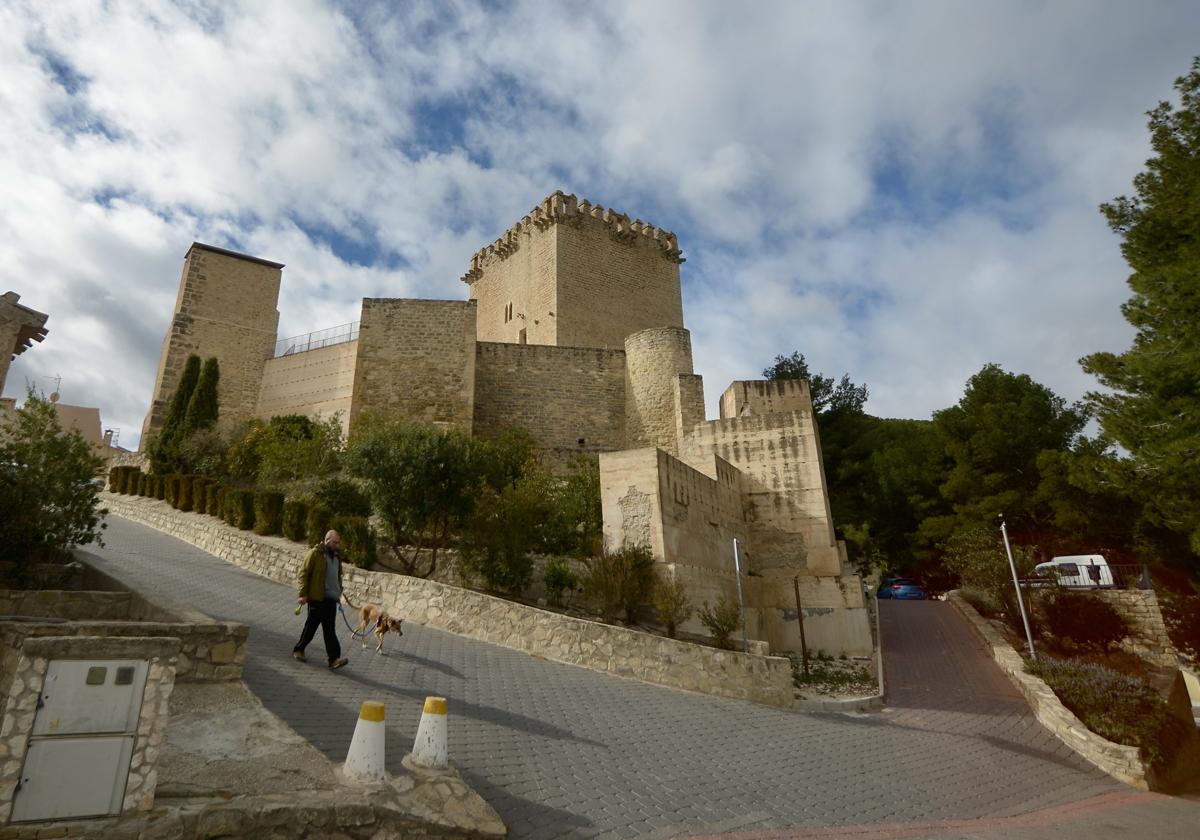 Un vecino pasea con su perro por los alrededores del castillo de Moratalla.