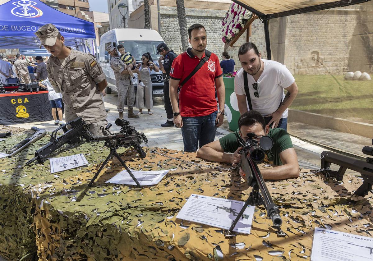 Varias personas observan las armas del ejército.