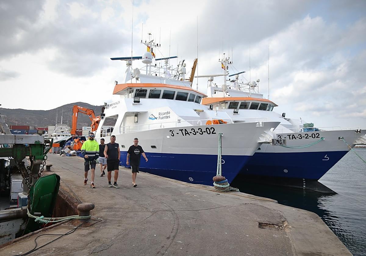 Un grupo de trabajadores junto a los dos barcos pesqueros de la empresa Ricardo Fuentes, en el puerto de pescadores un día antes de zarpar hacia aguas de Ibiza.