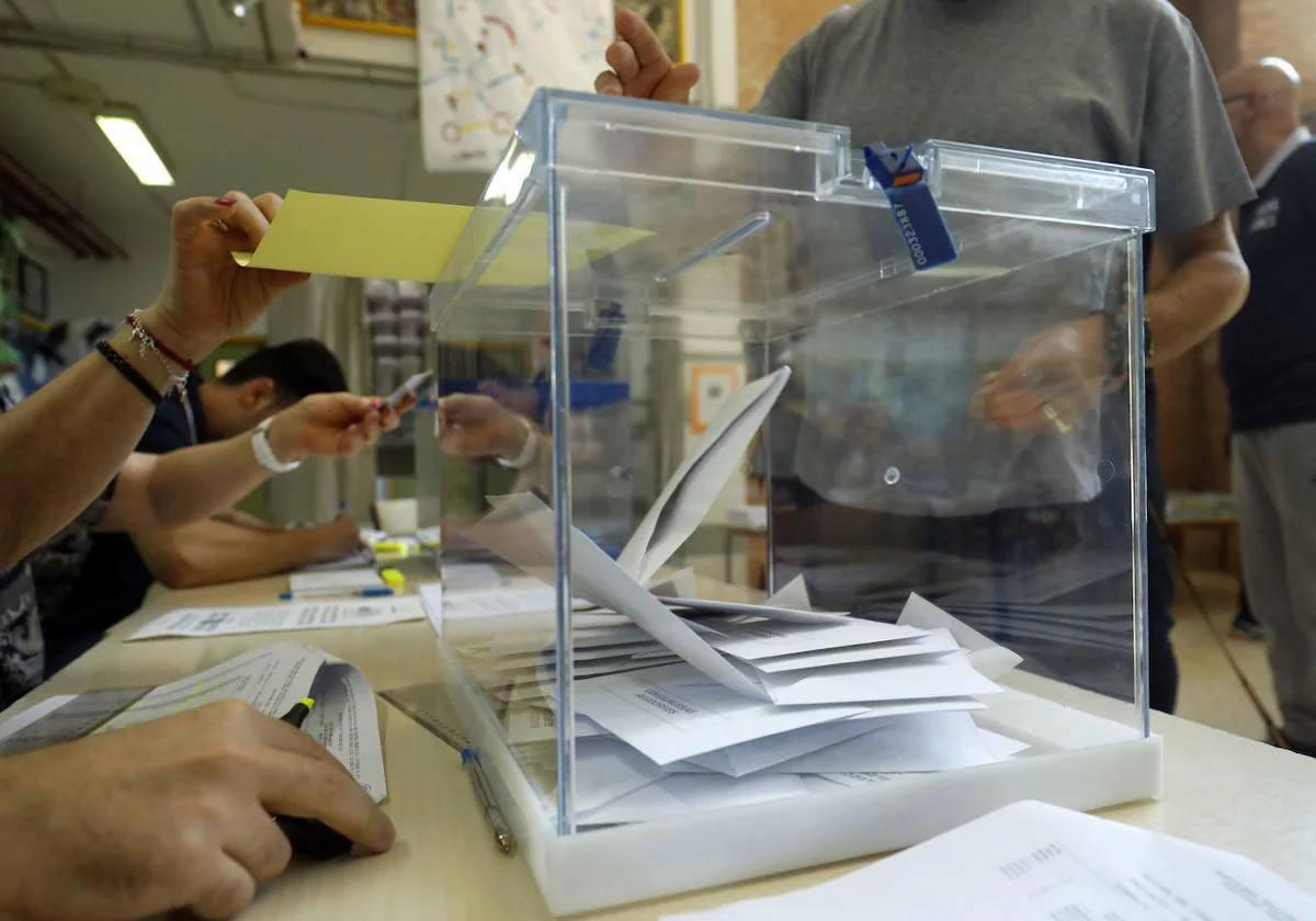 Imagen de archivo de unos ciudadanos depositando su voto en una urna.