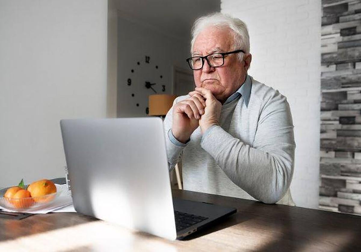 Un anciano realiza trámites a través de su ordenador.