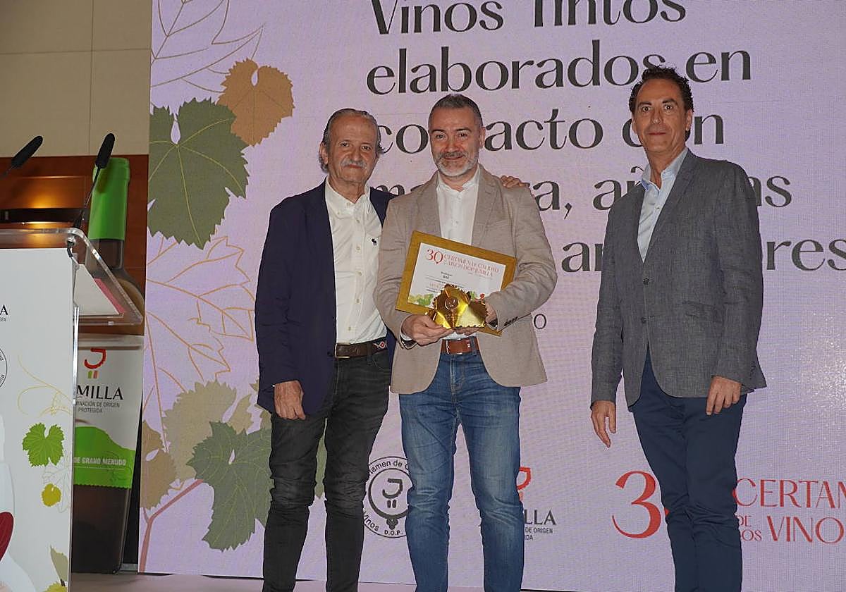 Luis Javier Pérez Prieto, director técnico de Bodegas BSI, recogiendo una medalla de oro de manos de dos miembros del jurado.