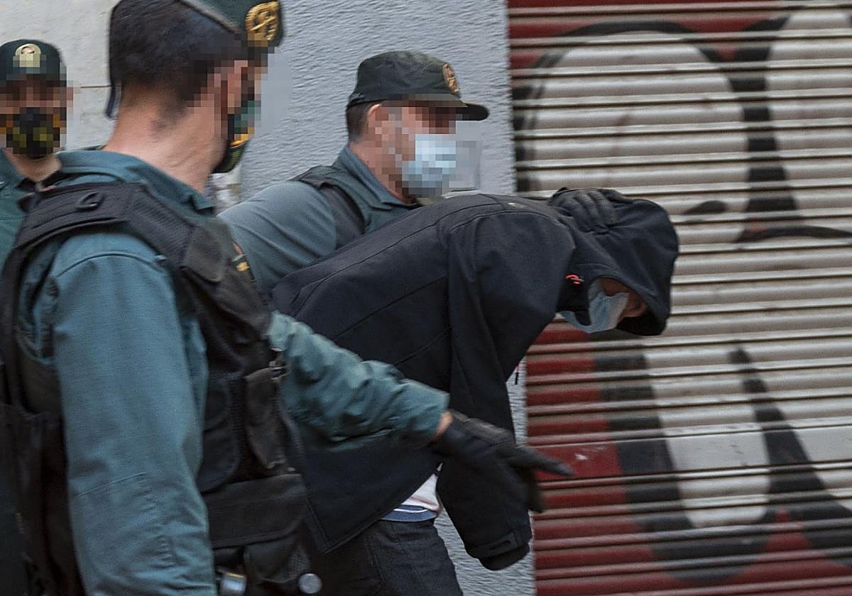 Agentes de la Guardia Civil trasladan a un fugitivo británico que se ocultaba en el murciano barrio de El Carmen.