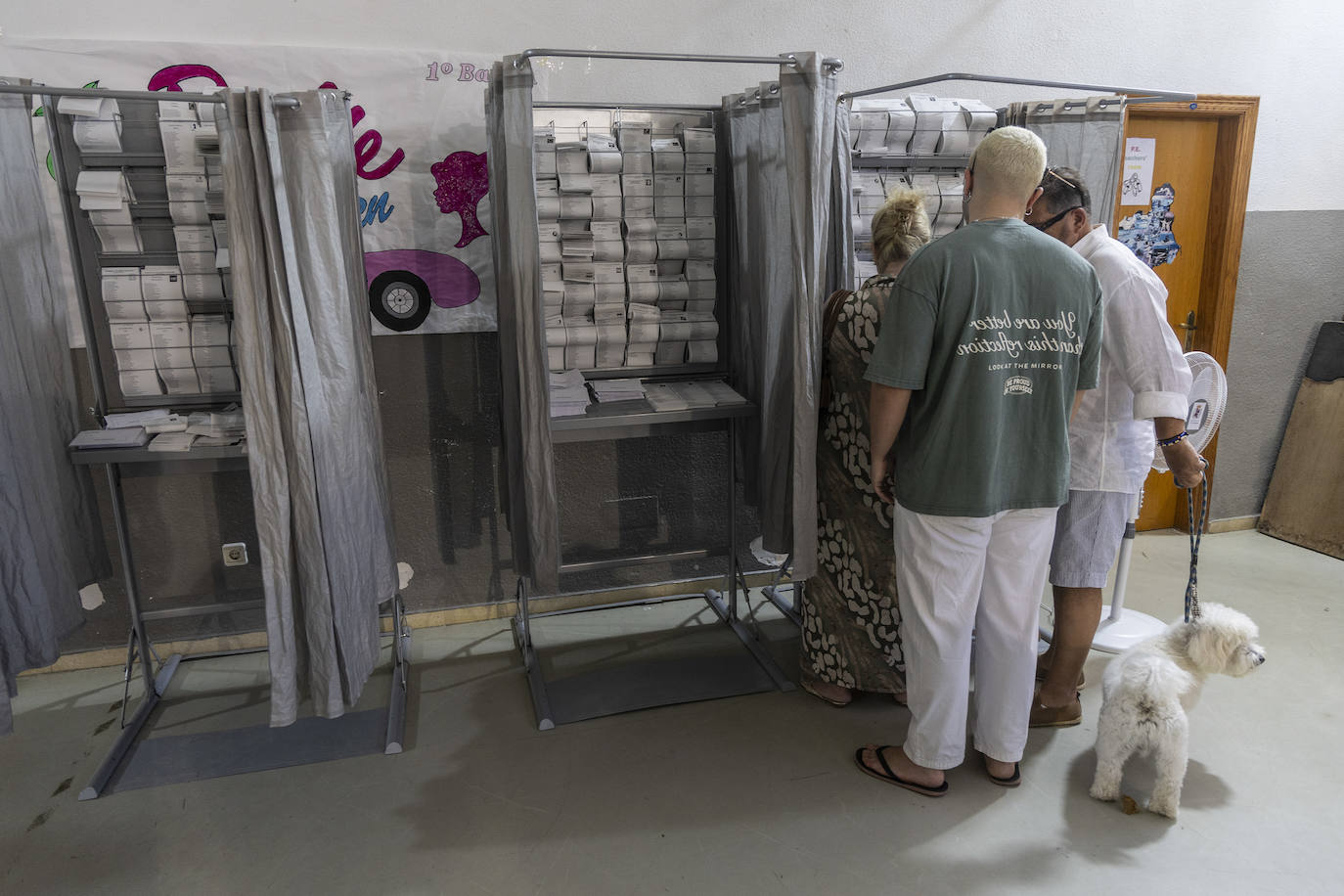 Una familia acompañada de su mascota, eligiendo en la mañana de ayer sus votos en un colegio electoral de Cartagena.