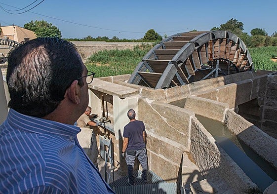 Dos operarios accionan la toma de agua a través de una de las dos norias.