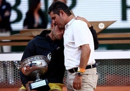 Carlos Alcaraz, con el trofeo de campeón de Roland Garros, se abraza a su padre, ayer.