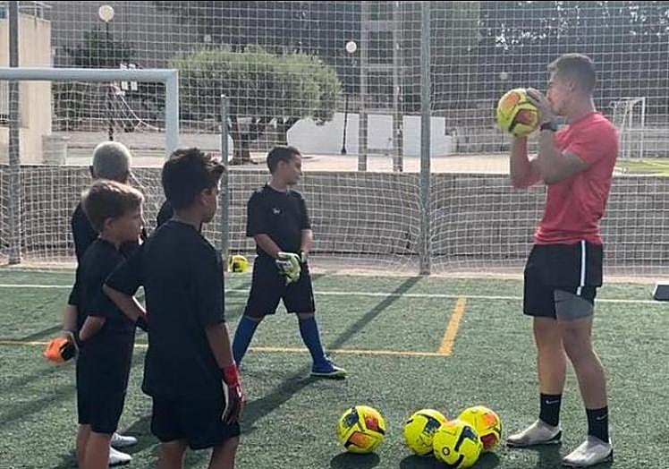 Aitor enseña una de las técnicas de bloqueo del balón a niños porteros en la Escuela Municipal de Benejúzar.