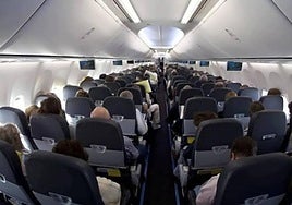 Vista interior de un avión con pasajeros.