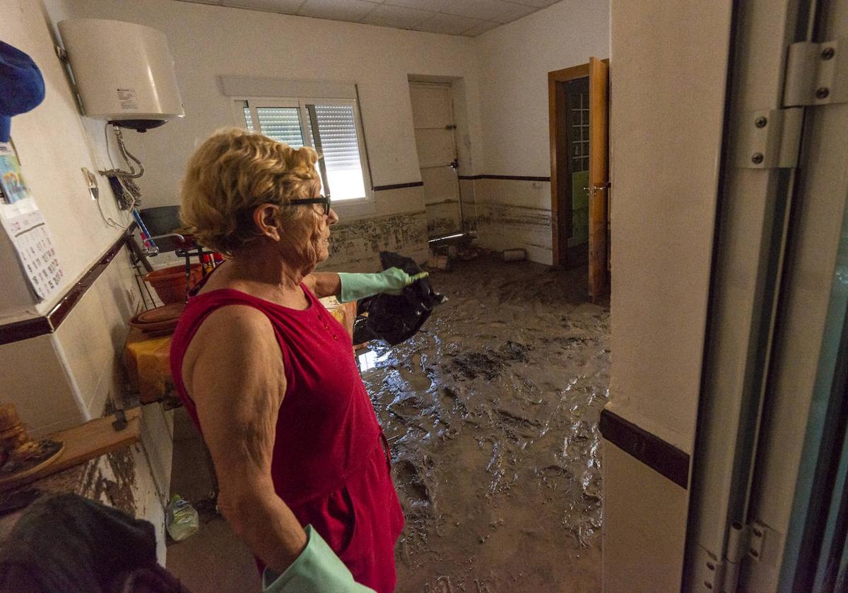 Catalina, una vecina de Ribera de Molina, limpia de barro su casa, cerca del cauce del río Segura, tras el paso de la tormenta.