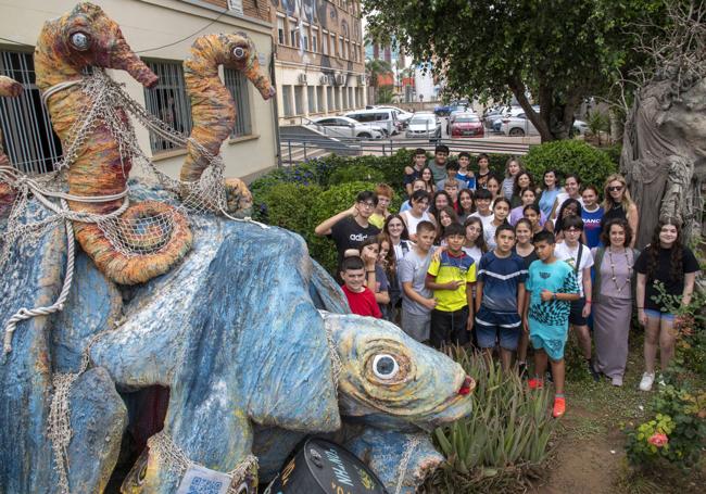 El equipo, junto a una escultura de material reciclado.