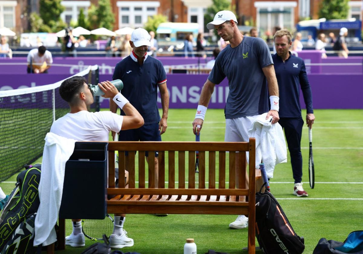 Carlos Alcaraz, sentado, en un descanso del entrenamiento de ayer en Queen's con Andy Murray, de pie a la derecha.