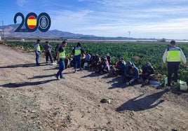 Los agentes de la Policía Nacional con los trabajadores de una de las explotaciones agrícolas.