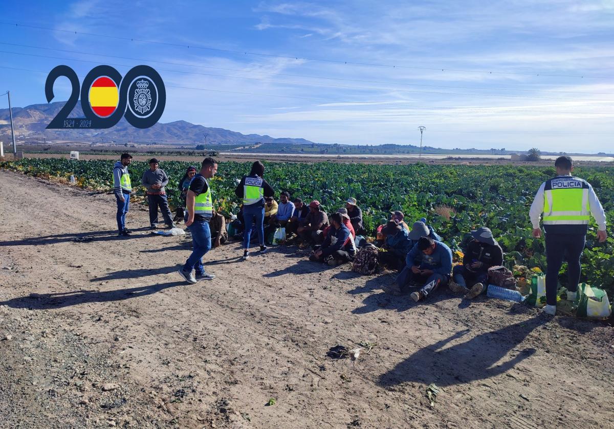 Los agentes de la Policía Nacional con los trabajadores de una de las explotaciones agrícolas.