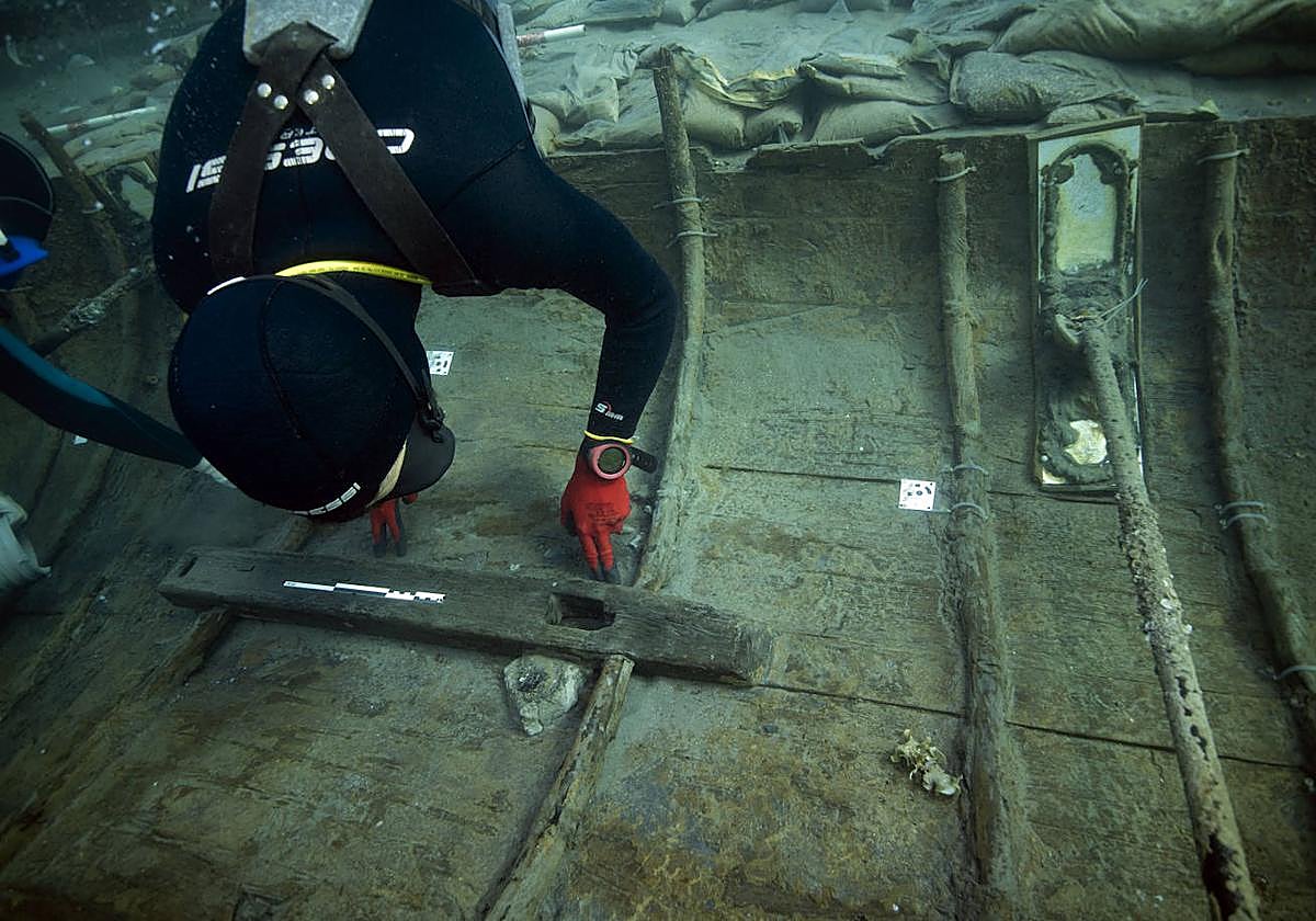 Un arqueólogo examina el interior del casco del barco fenicio hundido en Mazarrón, cuya antigüedad supera los 2.500 años.