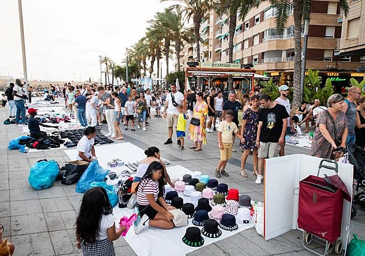 Hileras de mantas a ambos lados reducen significativamente el espacio para deambular por el paseo en una imagen del pasado verano.