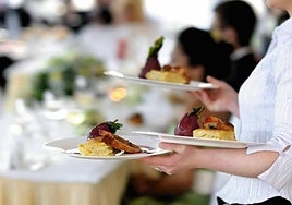 Imagen de archivo de una camarera sirviendo platos en una celebración.