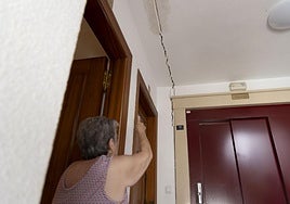 La vecina del edificio Ana María Paredes señala una de las grandes grietas que hay junto al ascensor del segundo piso.